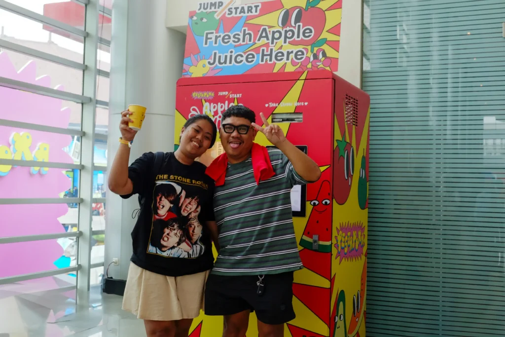 Pengunjung berpose di depan mesin Apple Juice JumpStart di Pestapora 2025