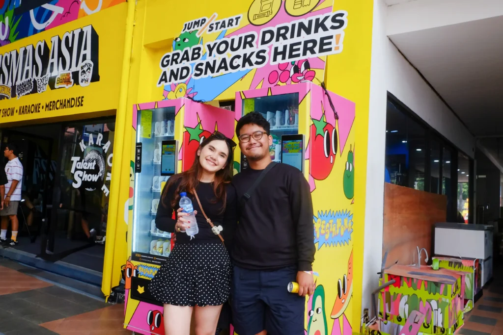 Pengunjung berpose di depan JumpStart Mart Machine berwarna cerah di Pestapora 2025